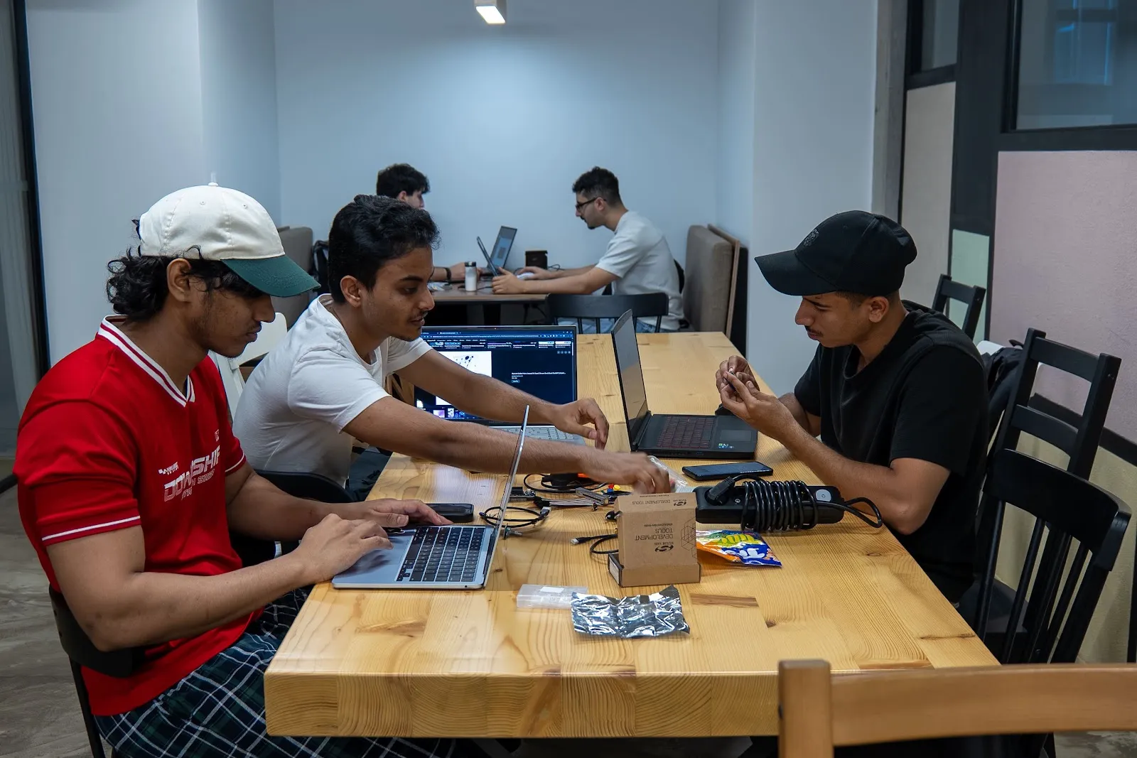 A team working with laptops and electronic components