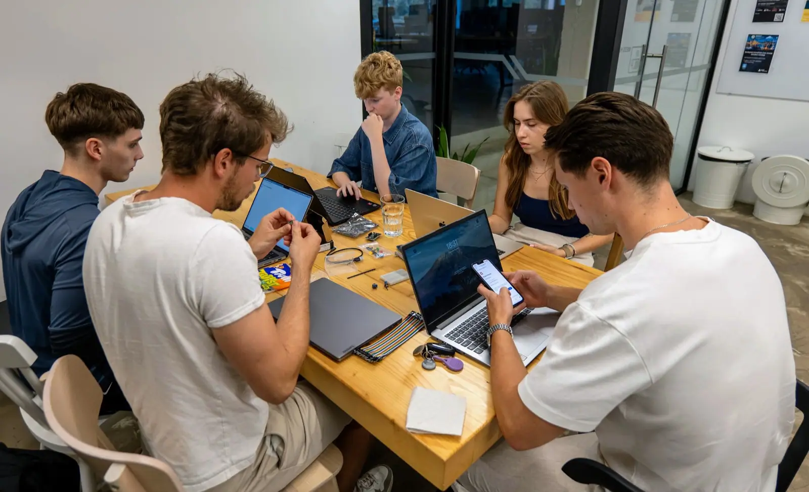 Members working together on laptops and hardware